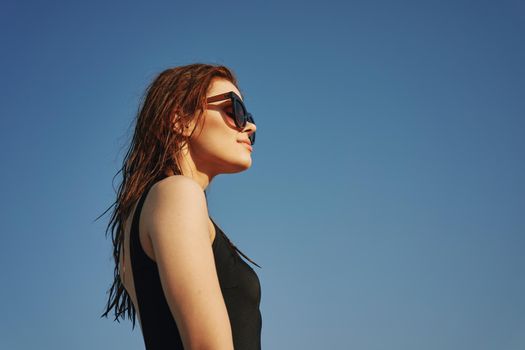 woman in black swimsuit sunglasses sun nature. High quality photo