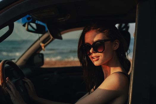 cheerful woman in sunglasses driving a car trip travel. High quality photo