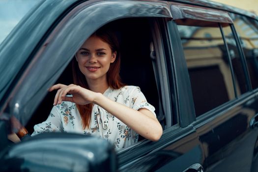 cheerful woman driving a car looks out of the window. High quality photo