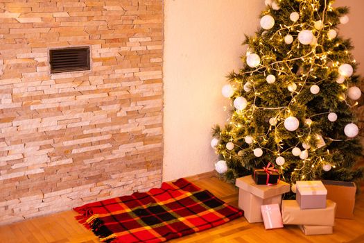 lighted Christmas tree with presents underneath in living room
