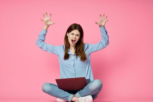 woman with laptop on pink background online shopping entertainment. High quality photo