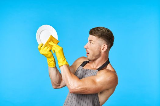 man in apron cleaning dishwashing blue background. High quality photo