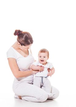 Close up view of attractive young mother with her baby wearing white on a white background