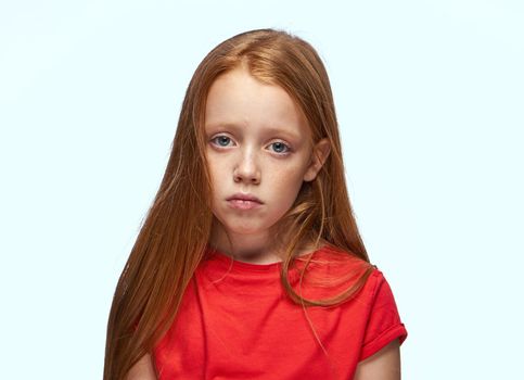 girl with red hair posing red t-shirt childhood. High quality photo