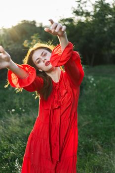 attractive woman in red dress outdoors in freedom field. High quality photo