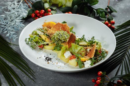 Summer diet salad with leaves of lettuce, watermelon, peach and feta cheese. On a light blue background copy space.