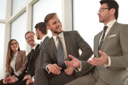 Cheerful businessmen meeting with colleagues in a bright office