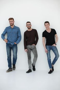 three casual men having a break and rest, standing by the wall in the studio