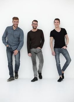 three casual men having a break and rest, standing by the wall in the studio