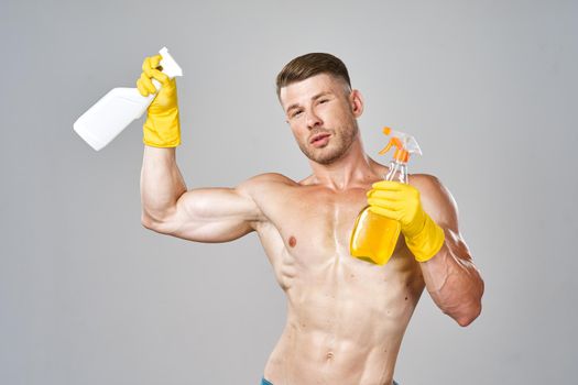 man with pumped up muscular body detergent rubber service gloves. High quality photo