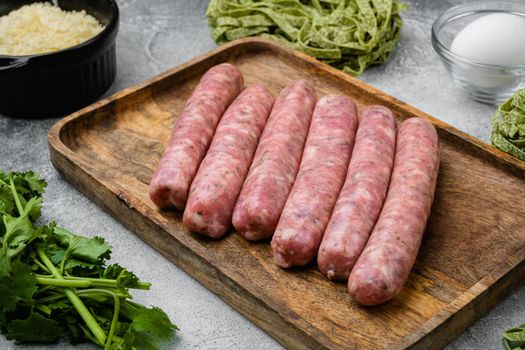 Raw Tagliatelle sausages ingredients set, on gray stone table background