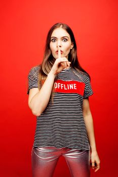 young pretty emitonal posing teenage girl on bright red background, happy smiling lifestyle people concept close up