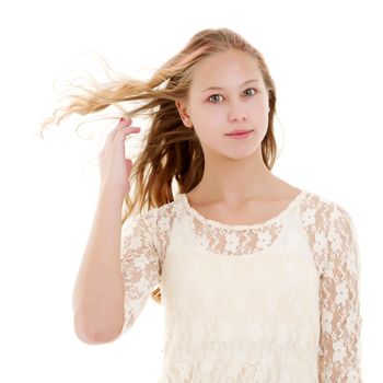 Portrait of a positive and stylish little girl in a summer dress, rejoices in the wind that blows and moves her dress and hair. The concept of beauty and fashion. Isolated on white background.