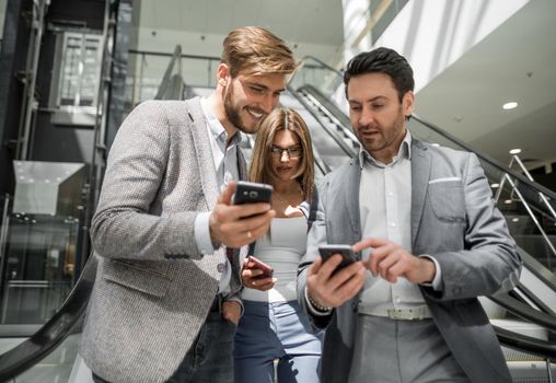 group of young businessmen looking at the screens of their smartphones. business concept