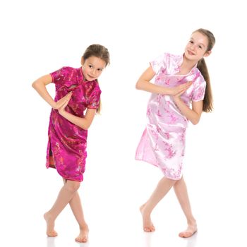 Lovely little girls in Chinese national dresses. The concept of a happy childhood, style and fashion. Isolated on white background.