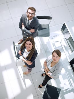 top view.business colleagues standing near the desktop . business concept