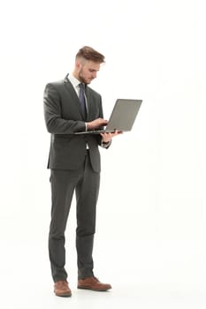 Full-length portrait of a businessman standing and using laptop isolated on a white background