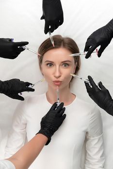 Conceptual beauty and cosmetology image of the hands of several beauticians holding their respective equipment. Beauty concept. Cosmetology concept. Cosmetology salon. Cosmetic procedures mesotherapy