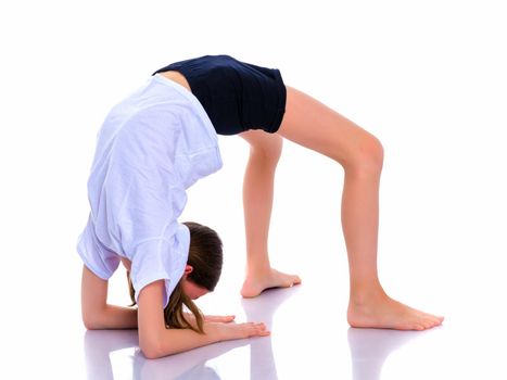 A girl gymnast performs an acrobatic element on the floor. The concept of childhood, sport, healthy lifestyle. Isolated on white background.