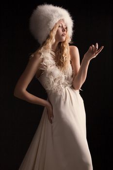 The beautiful young woman posing in a wedding dress