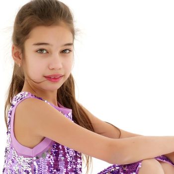 Cute girl posing on the floor in the studio. Hugs his knees. Isolated on white background. The concept of beauty and fashion