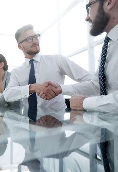 background image.handshakes colleagues at the Desk .business concept