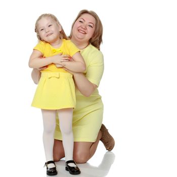 Mom and little daughter plus the size of the model, gently embrace. A woman and her daughter are smiling in a happy manner. Good for the concept of health, happiness, diet, obesity, weight loss.