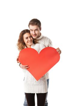 beautiful young couple holding a red heart isolated over white background