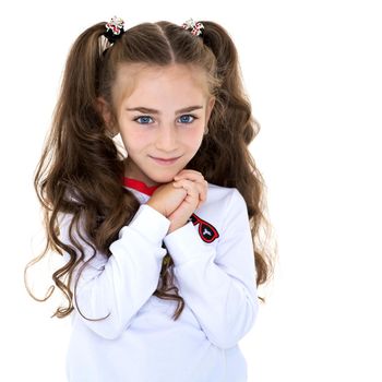 A charming little girl folded her hands around her face. The concept of beauty and fashion, children's emotions. Isolated on white background.