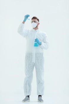 in full growth.a scientist in a protective suit looking at a bottle of liquid