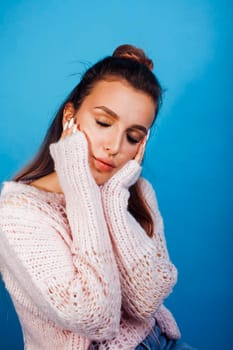 young pretty modern hipster girl posing emotional happy on blue background, lifestyle people concept close up