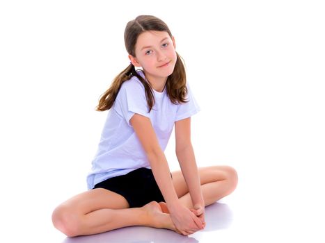 A girl gymnast performs an acrobatic element on the floor. The concept of childhood, sport, healthy lifestyle. Isolated on white background.