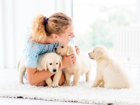 Nice girl and retriever puppies on light room