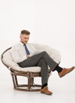 successful businessman using a digital tablet, sitting in a chair.photo with copy space