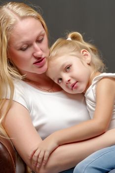 Young mother and little daughter gently embrace. The concept of Happy Childhood, Family Happiness, Raising a Child.