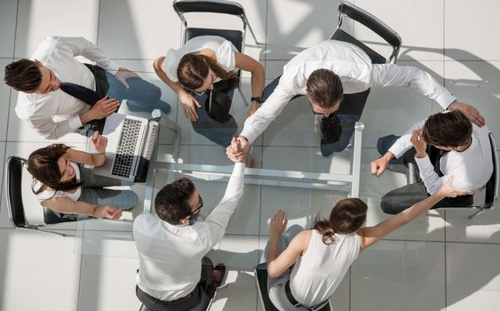 top view.company employees giving each other high five.success concept