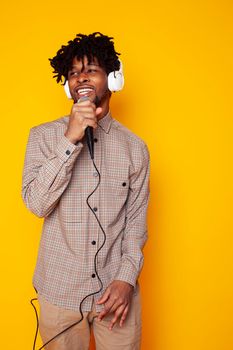 young handsome african american guy student posing cheerful and gesturing on yellow background, lifestyle people concept close up