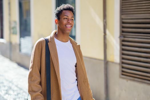 Young Cuban man standing in the street. Student in urban background.