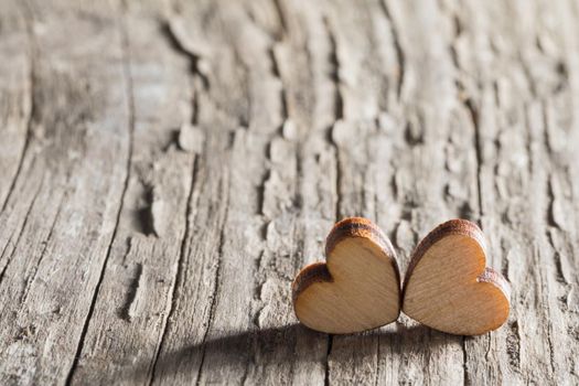 Two small wooden carved hearts on rustic wood background couple relationship Valentine day concept, copy space for text