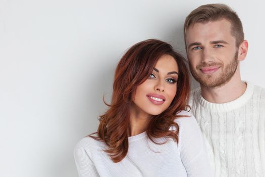 Happy young couple in love wearing white clothes over white background