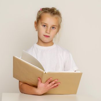 Little girl with book. The concept of education in school or kindergarten. Isolated over white background