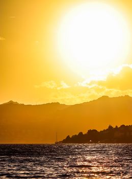 Beautiful sunset on the coast of the Aegean Sea with mountains and boats. Summer vacation and coastal nature concept