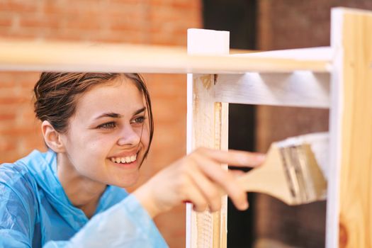 woman paints wood painter repair protective suit. High quality photo