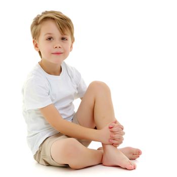 A sad little boy in a pure white T-shirt on the surface of which you can make a drawing or write advertising text. Isolated on white background.
