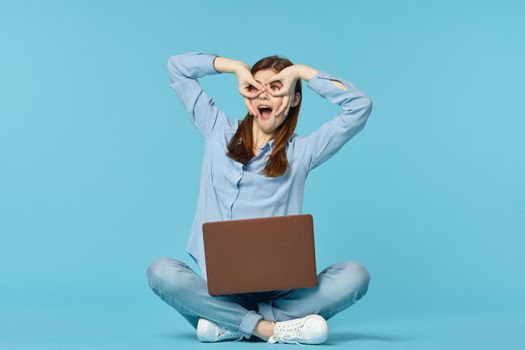 woman student sitting on floor with laptop education blue background. High quality photo