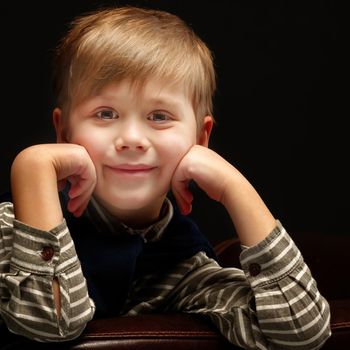 Cute little boy in studio on a black background. Concept Happy childhood, beauty and people.