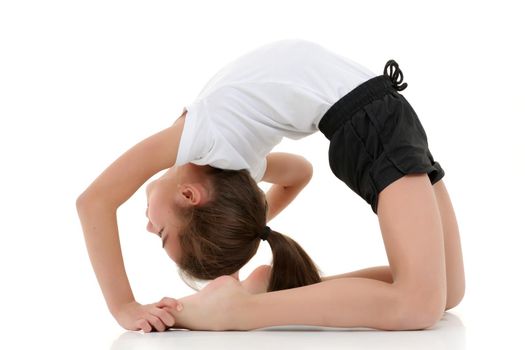 A little girl gymnast performs a bridge. The concept of childhood, sport, healthy lifestyle. Isolated on white background.