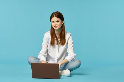 woman with laptop learning internet online education blue background. High quality photo