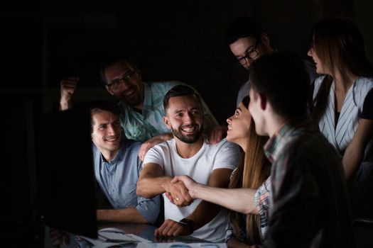 business colleagues shaking hands at the Desk.the concept of overtime