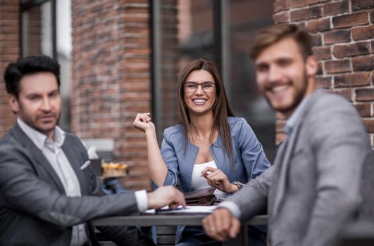employees of the company sitting at a table in a street cafe.the concept of teamwork